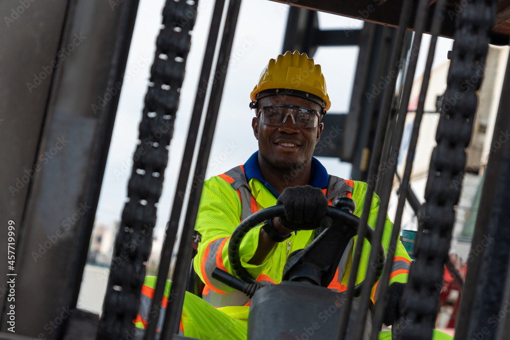 African american man driving forklift in shipyard . Logistics supply chain management and internatio