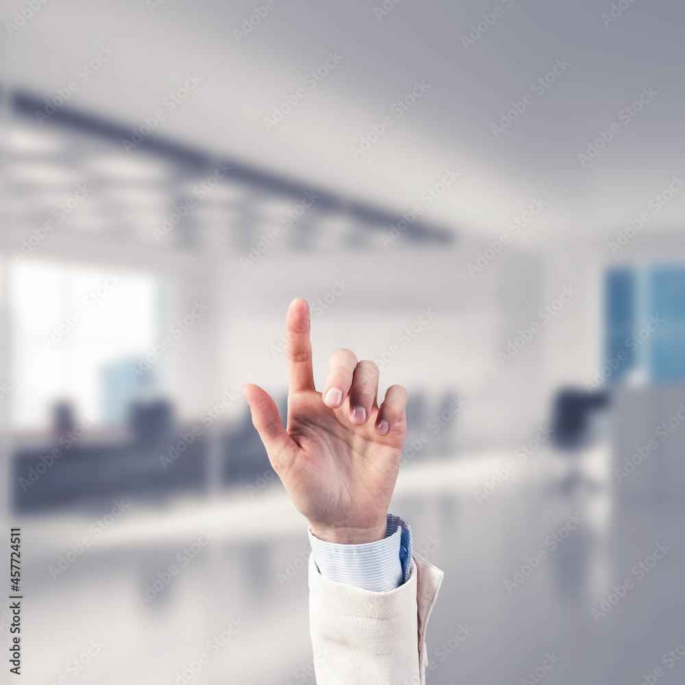 Choosing gesture of businessperson in elegant modern interior in sunshine light