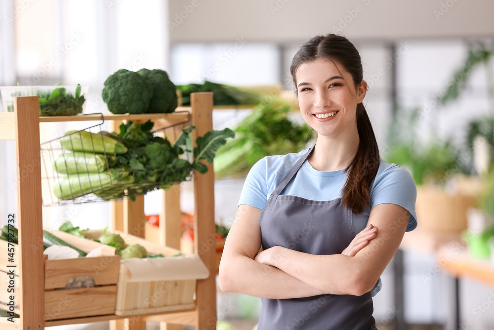 Female seller with fresh vegetables in market