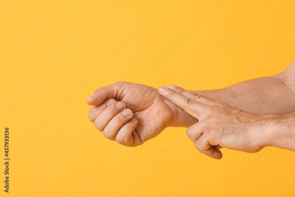 Man checking pulse on color background