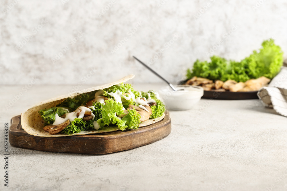 Wooden board with tasty Fajitas on light background