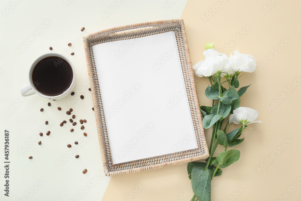 Blank magazine with wicker tray, cup of coffee and flowers on light background