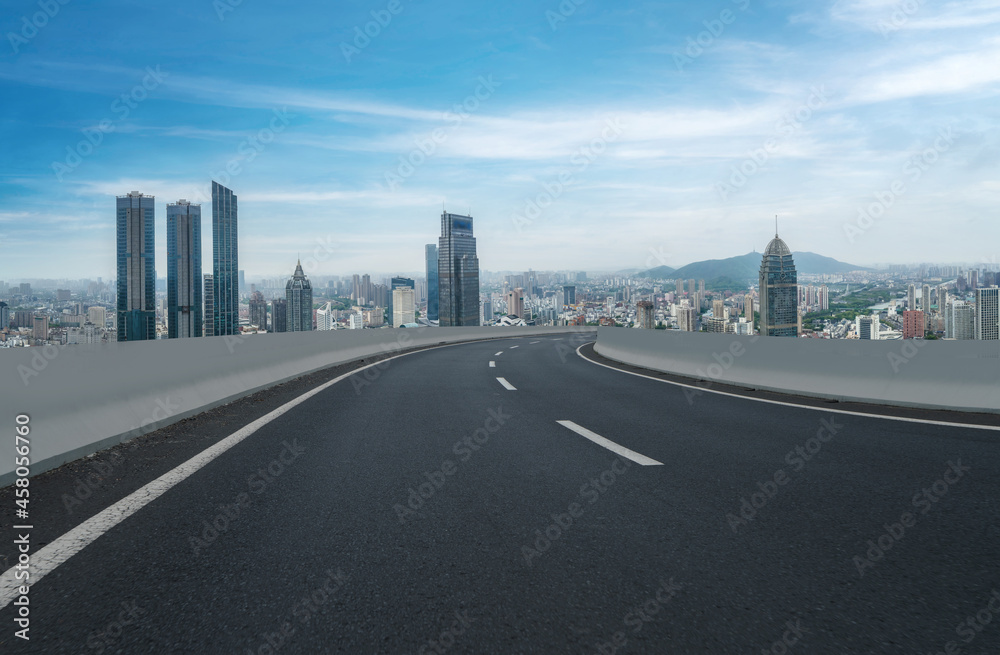 Panoramic skyline and empty asphalt road with modern buildings