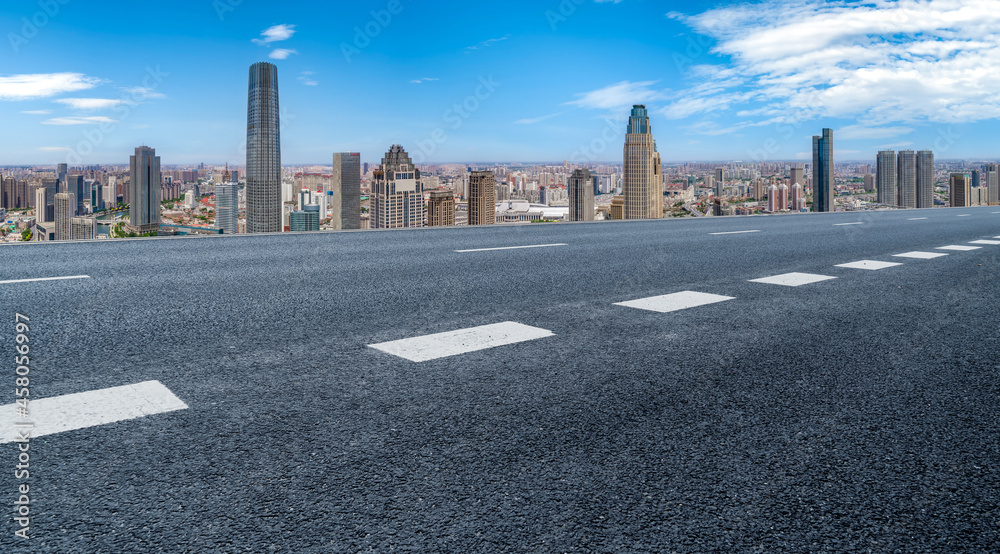 Panoramic skyline and empty asphalt road with modern buildings