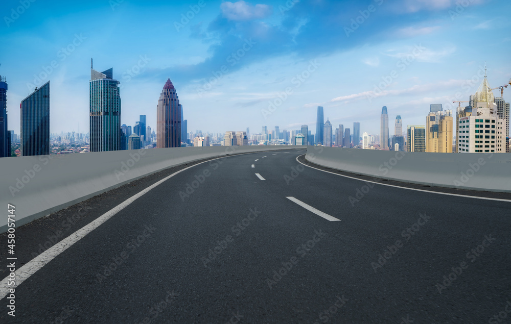 Panoramic skyline and empty asphalt road with modern buildings