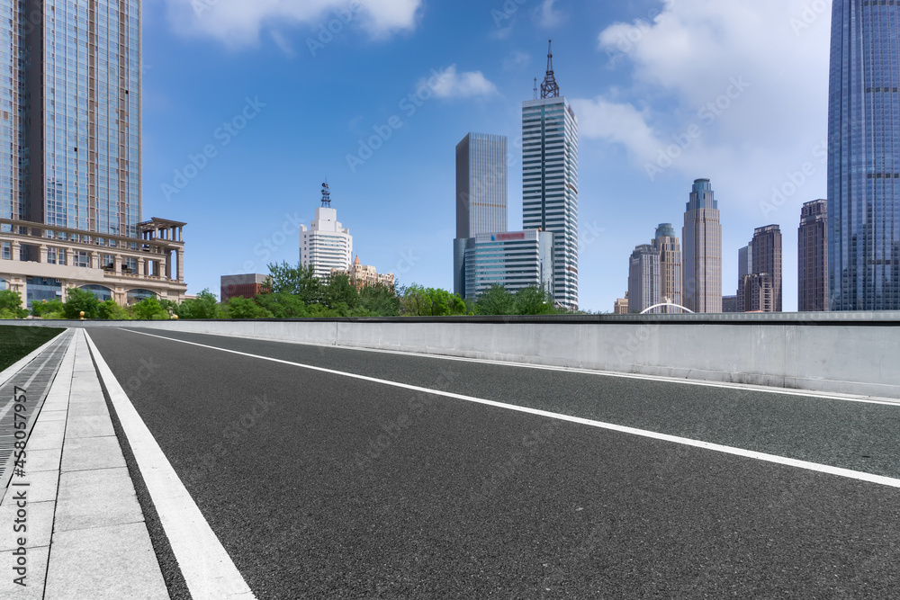 Panoramic skyline and empty asphalt road with modern buildings