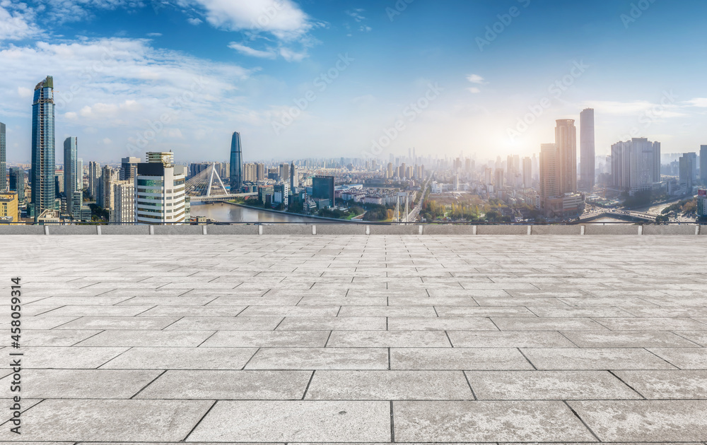 Panoramic skyline and empty square floor tiles with modern buildings