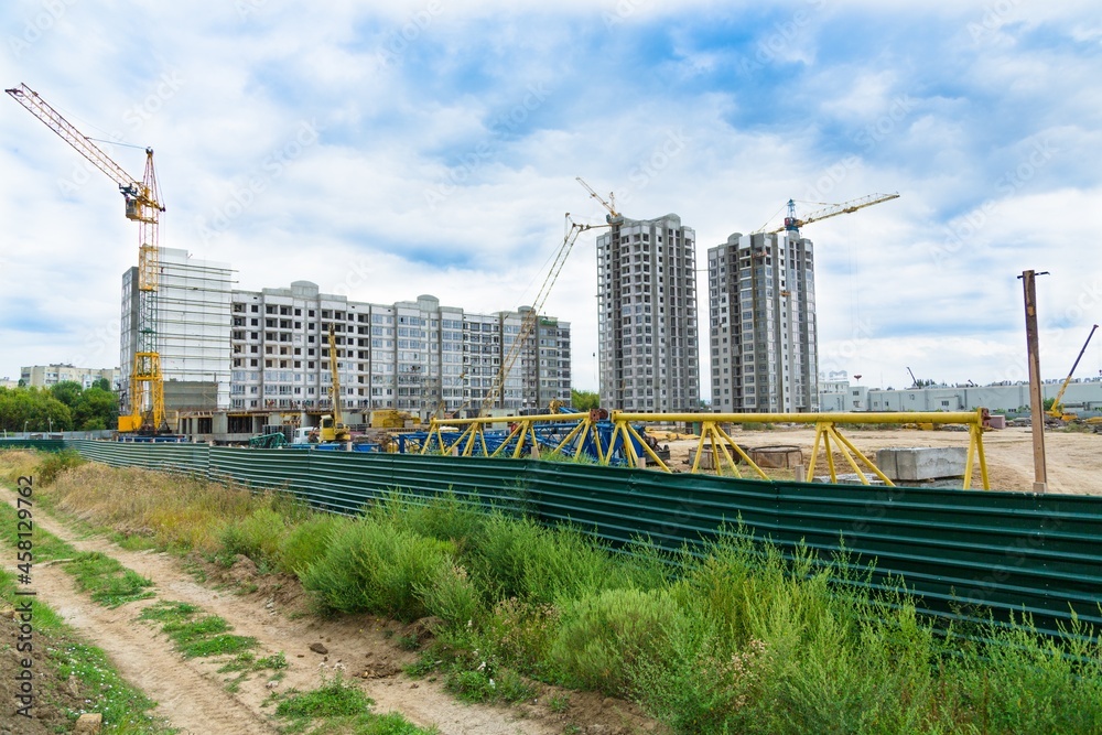 大型建筑工地，包括在建筑群上工作的几台起重机，天空晴朗