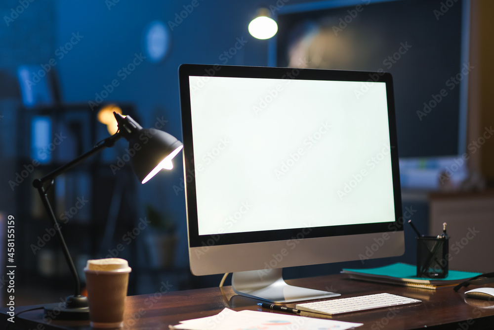 Workplace with modern computer in office at night