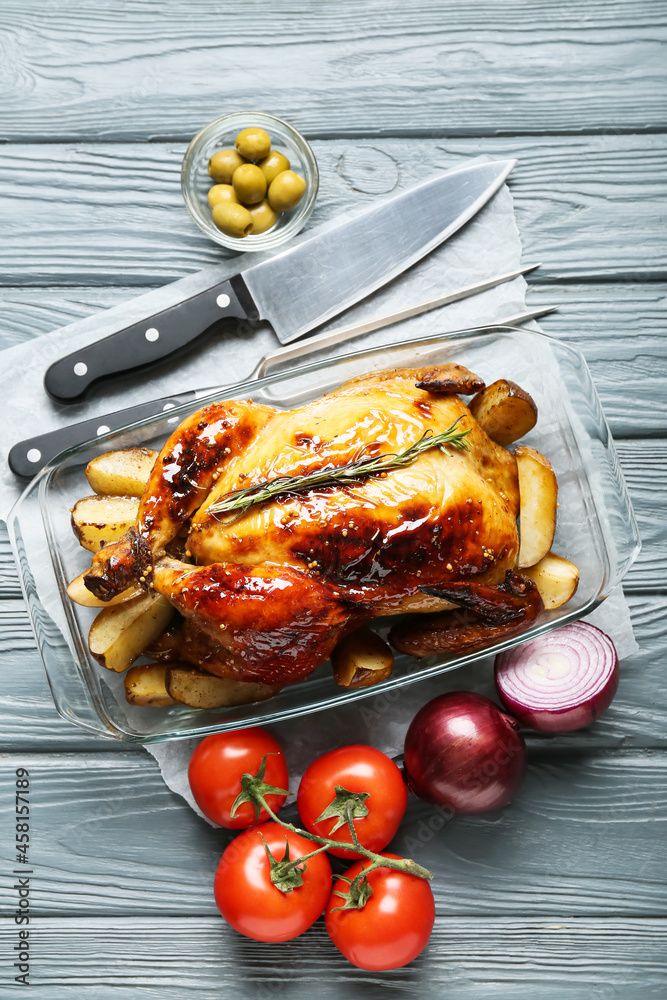 Baking dish with tasty chicken and vegetables on color wooden background