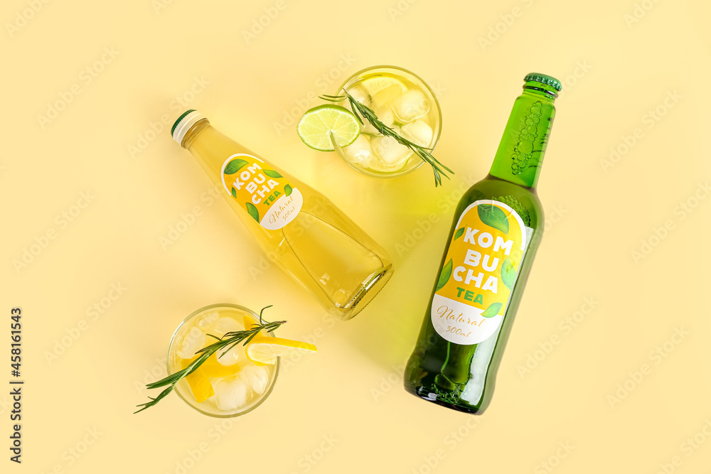 Composition with fresh kombucha tea in bottles and glasses on color background