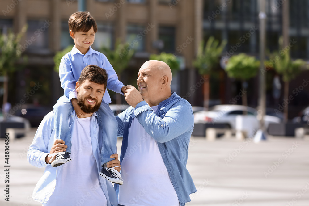 快乐的男人，他的小儿子和父亲在户外散步