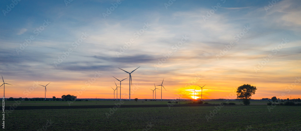 Amazing sunset over the field with wind turbines in Poland