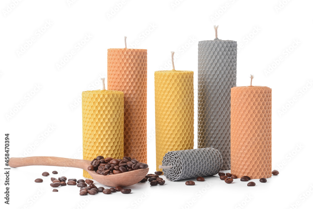 Composition with wax candles, wooden spoon and coffee beans on white background