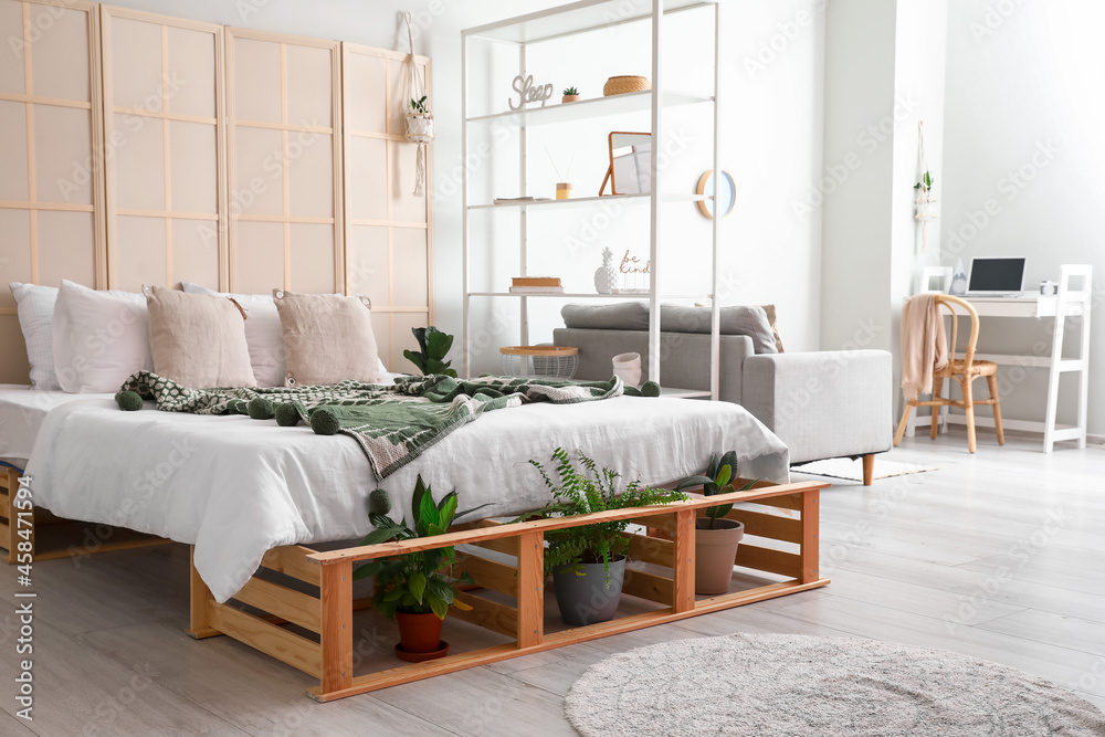 Interior of stylish bedroom with folding screen