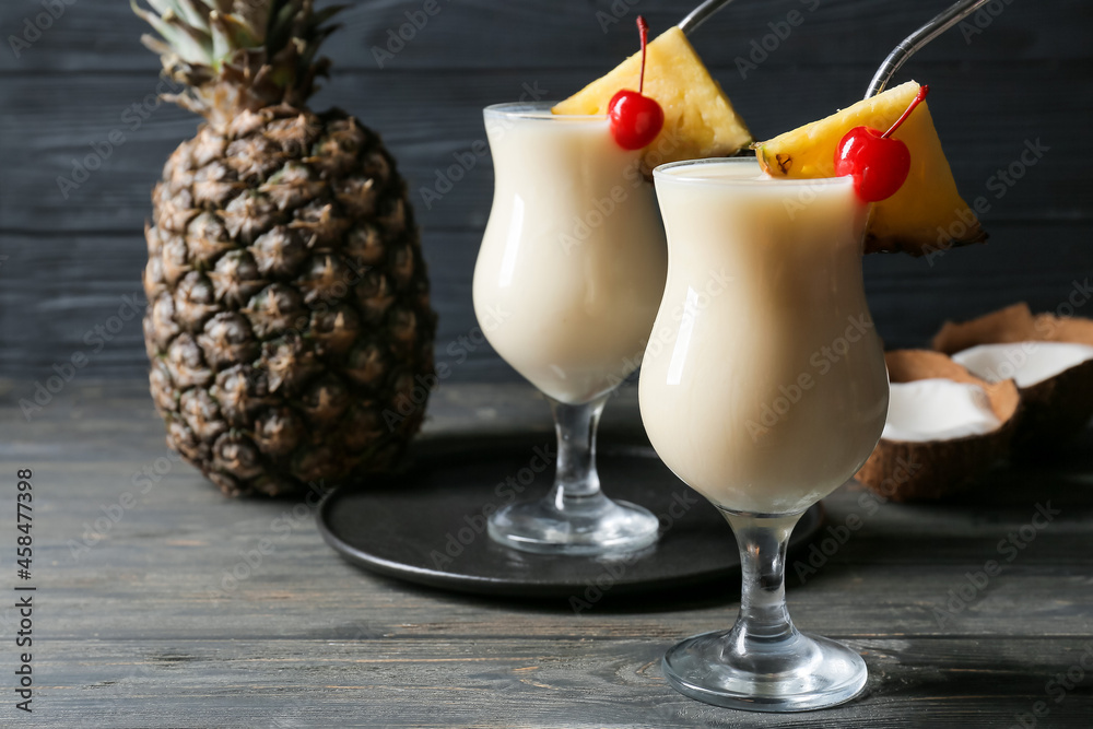 Glasses with tasty Pina Colada cocktail on wooden background