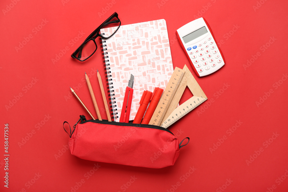 Set of stationery supplies and glasses on color background