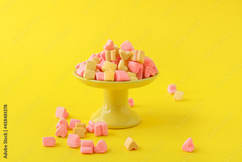 Dessert stand with marshmallows on yellow background