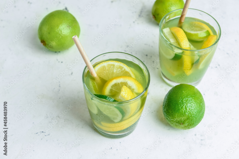 Glasses with tasty green lemonade on light background