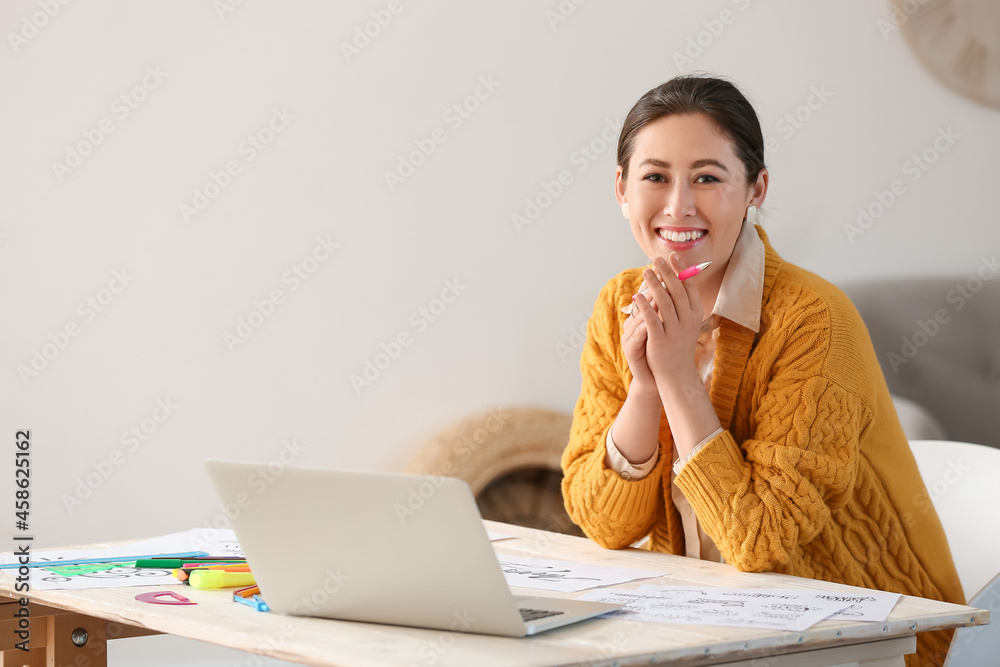 Young female calligraphist working in office