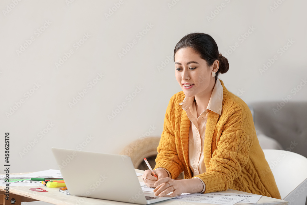 Young female calligraphist working in office