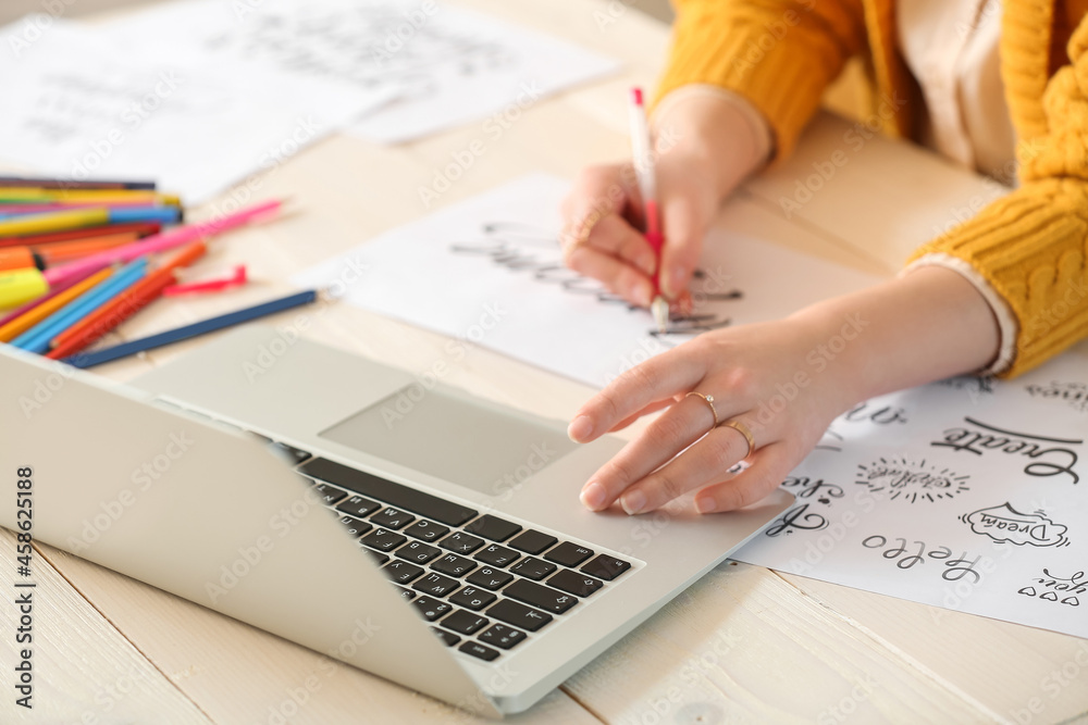 Young female calligraphist working in office