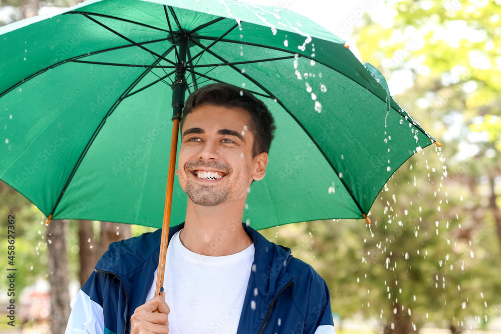 雨天公园里带伞的英俊青年