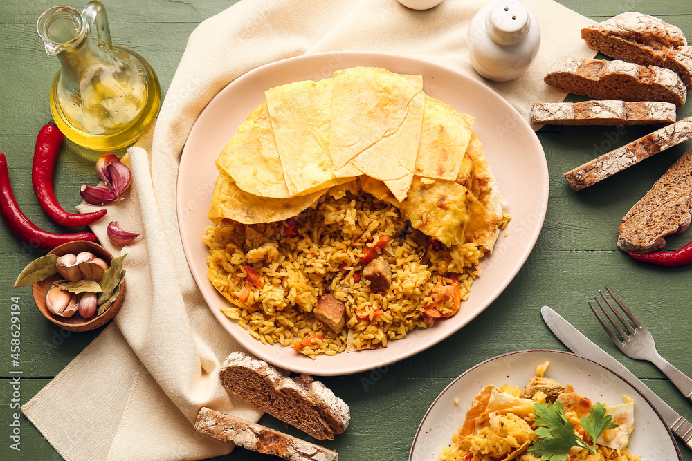 Plates with tasty Shah Pilaf and bread on color wooden background