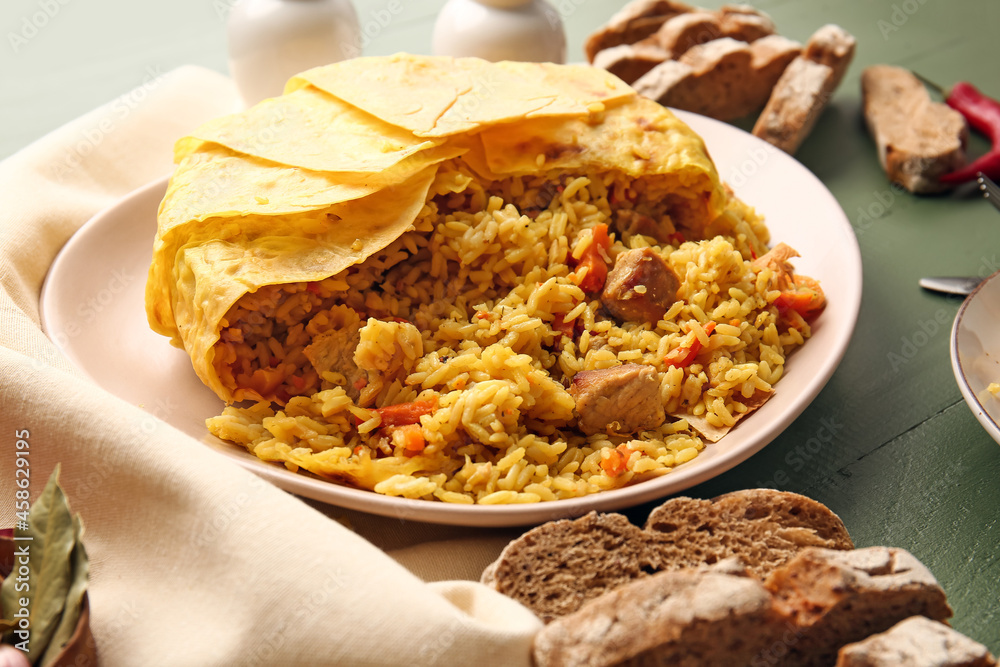 Plate with tasty Shah Pilaf on color wooden background