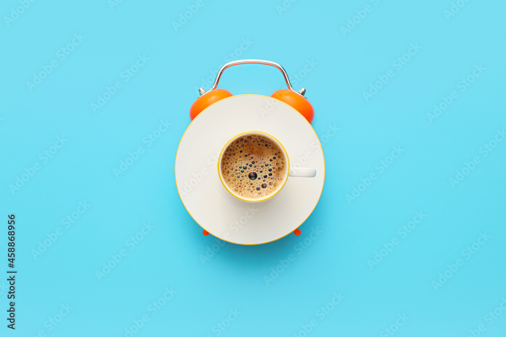 Creative alarm clock made with cup of coffee on blue background