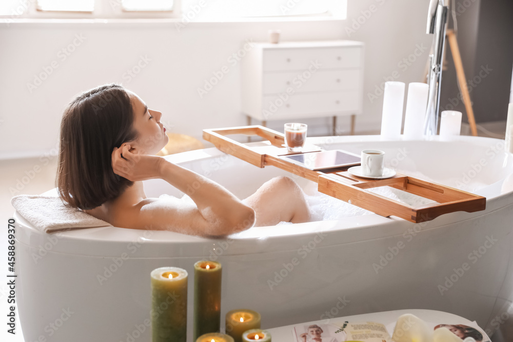 Young woman taking relaxing bath at home