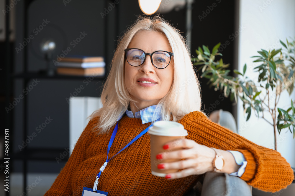 Mature businesswoman drinking coffee in office