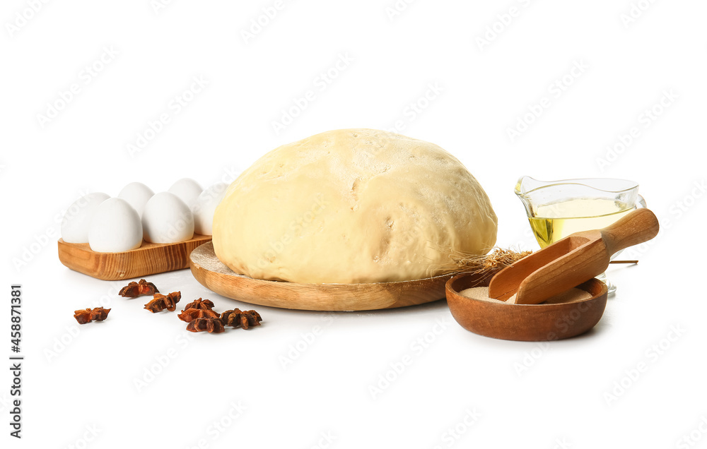 Wooden board with fresh dough, dry yeast and ingredients on white background