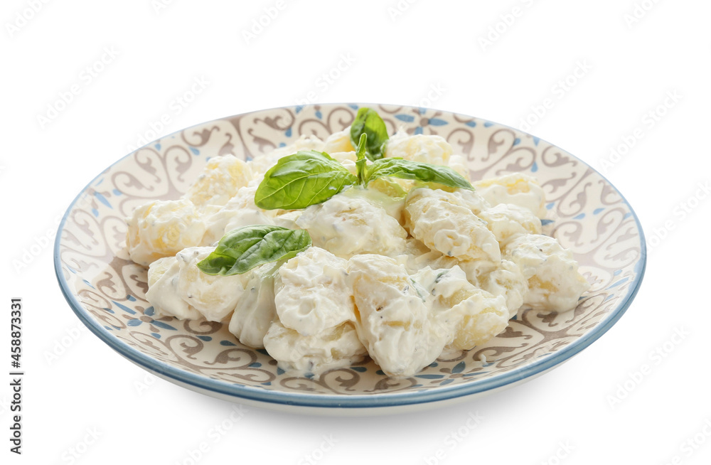 Plate of delicious gnocchi with creamy sauce on white background