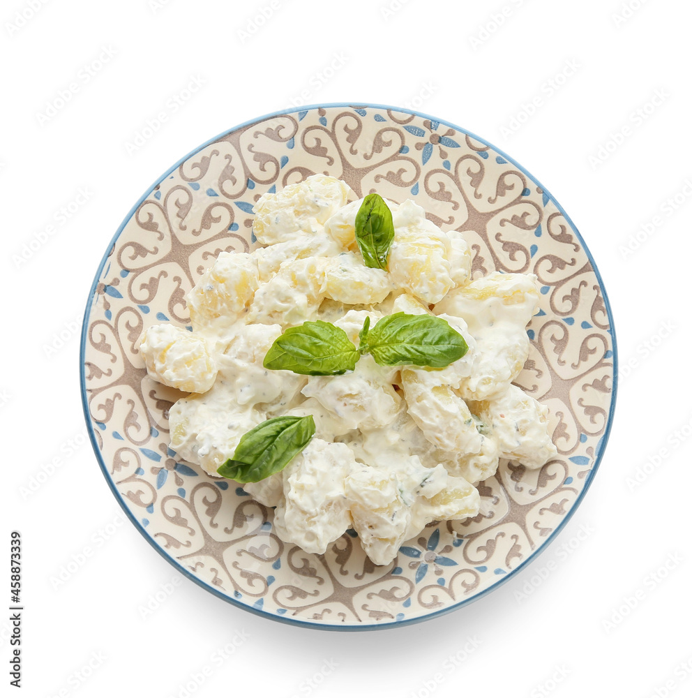 Plate of delicious gnocchi with creamy sauce on white background