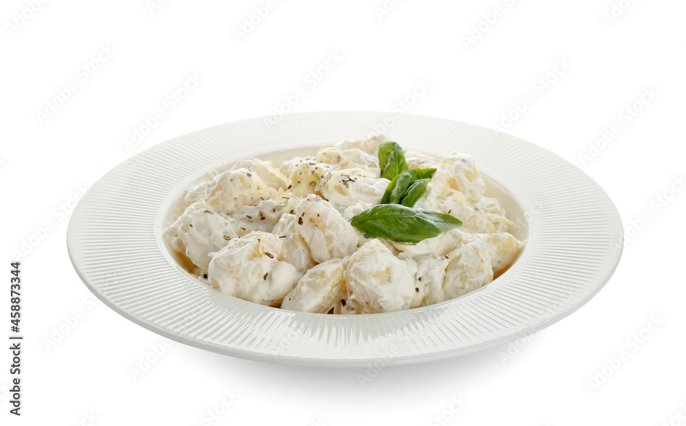 Plate of delicious gnocchi with creamy sauce on white background