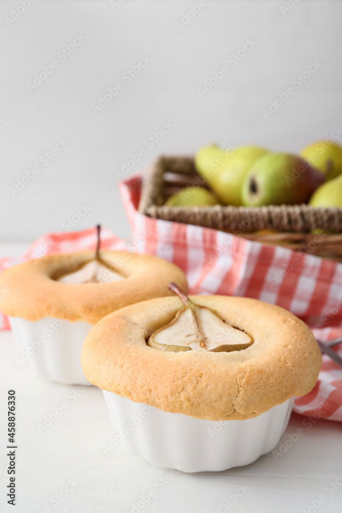 Tasty pear pot pies on light wooden background