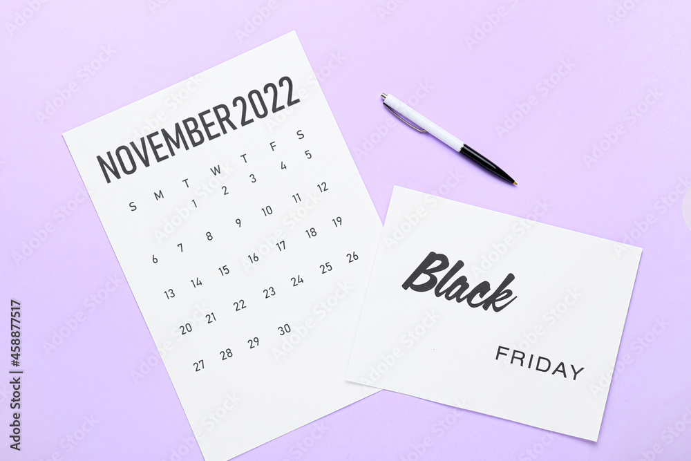 Calendar page of November 2022 and pen on color background. Black Friday