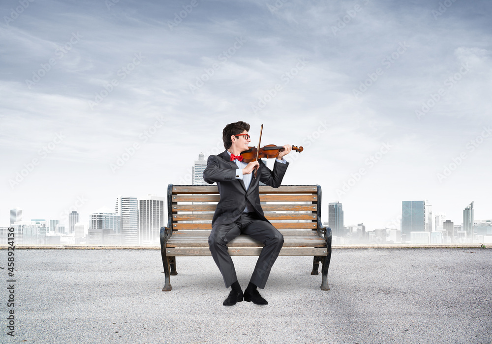 Young businessman plays the violin