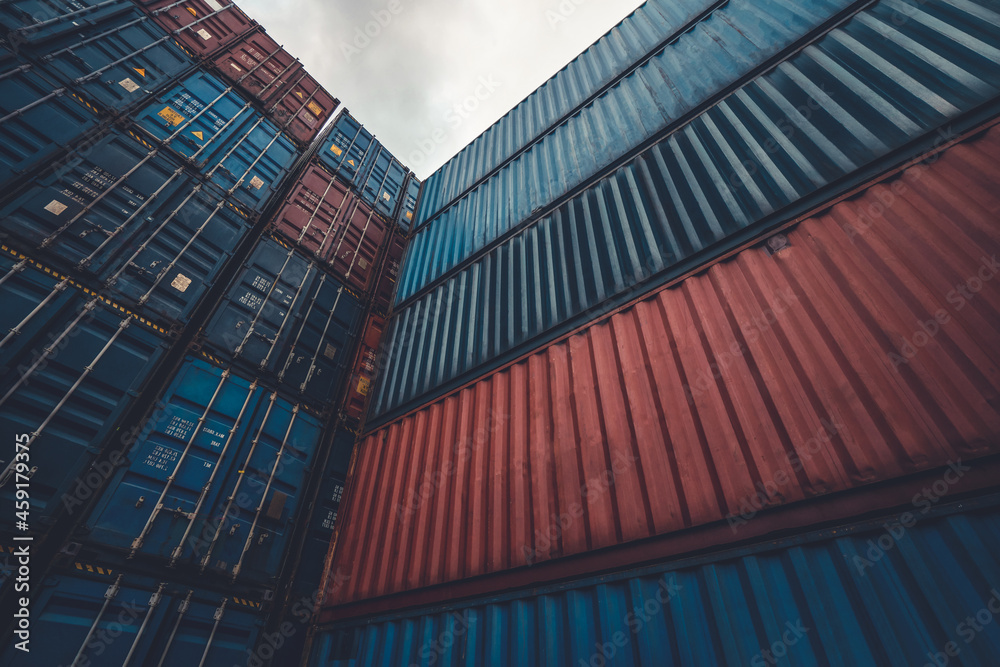 Cargo container for overseas shipping on high stack look up from ground . Logistics supply chain man