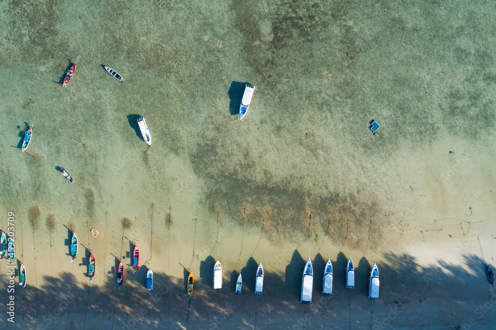 Aerial view top down of Thai traditional longtail fishing boats in the tropical sea beautiful beach 