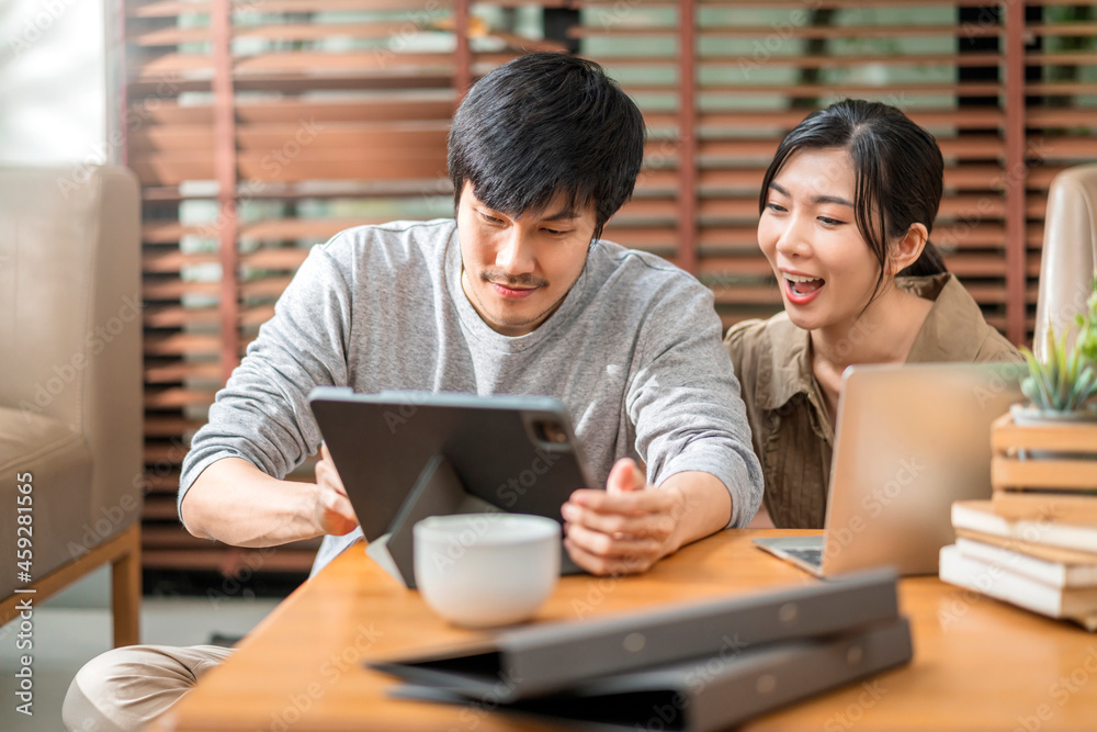 居家隔离隔离，亚洲人和爱人结婚的夫妇坐着用笔记本电脑和平板电脑放松