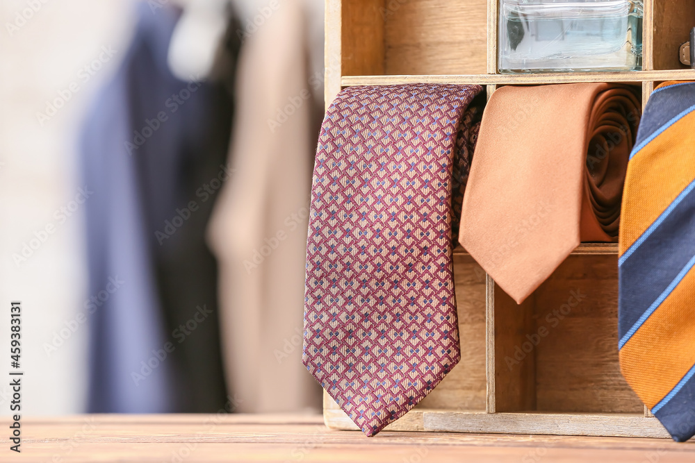 Box with many stylish neckties on table, closeup