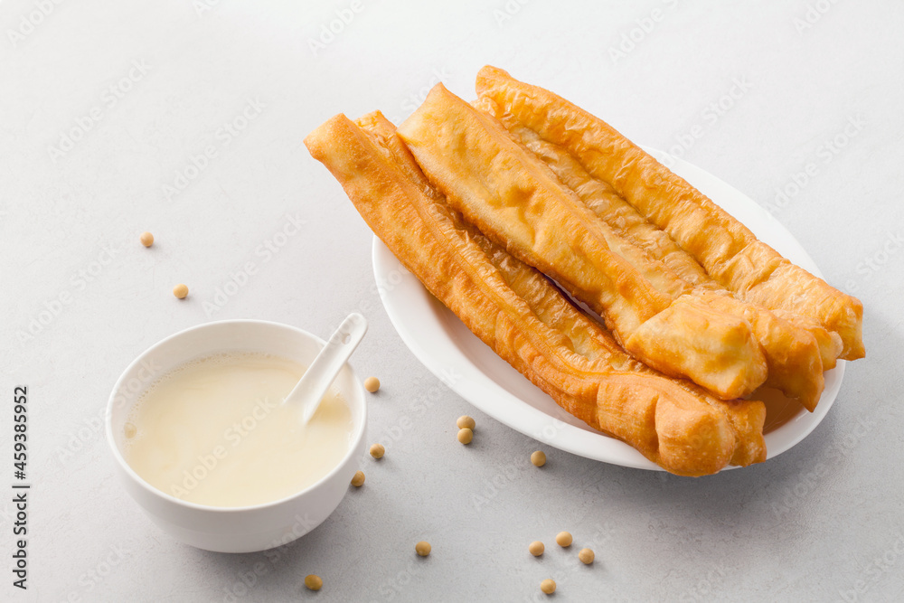 Traditional Chinese breakfast soy milk and dough sticks on table.