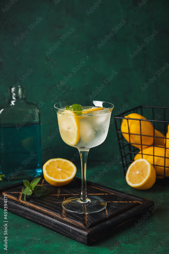 Glass of cold gin tonic on color background