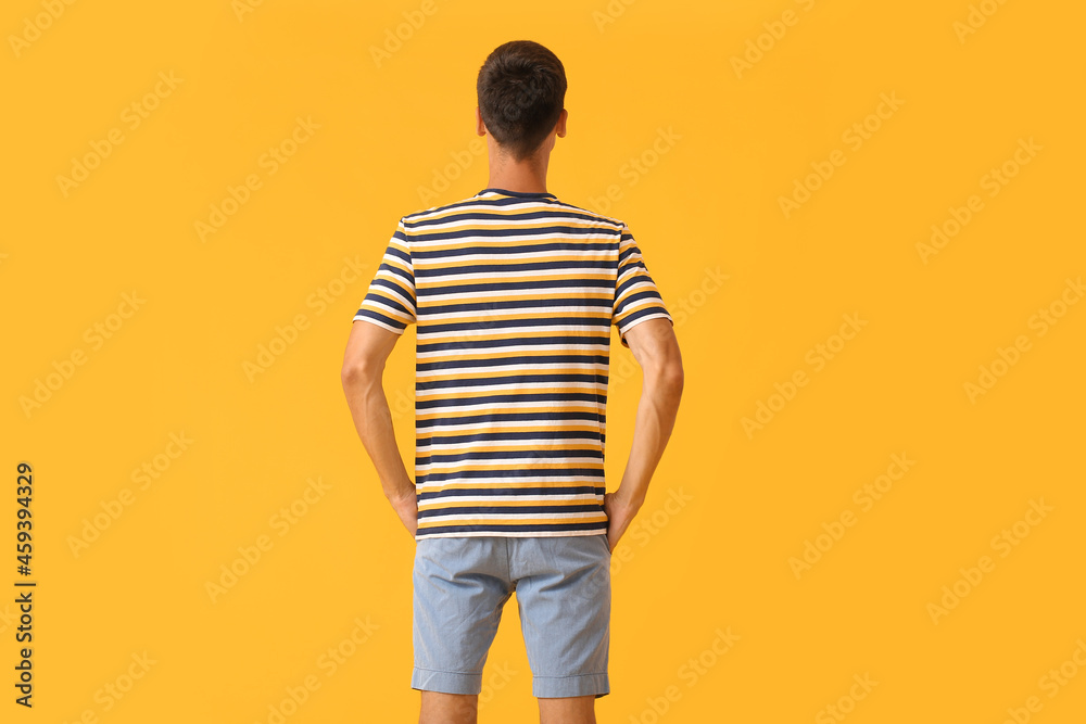 Handsome young man in stylish t-shirt on color background