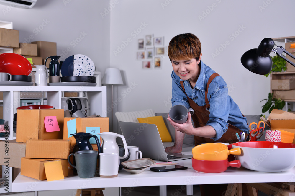 Mature Asian woman entrepreneur, Business owner working at home office with her clay ceramic product