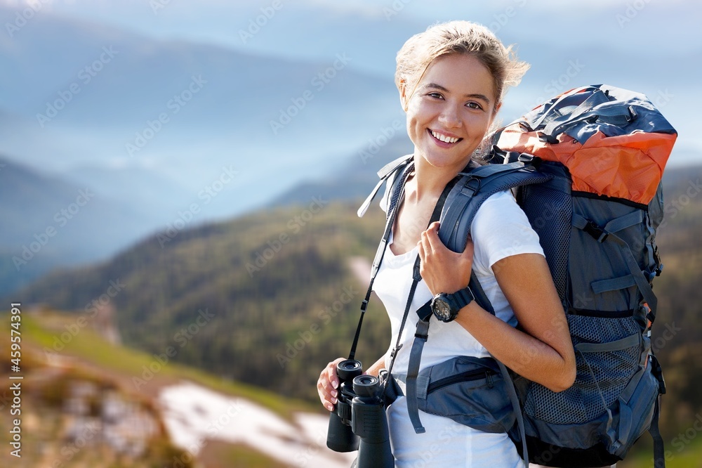 Young hiker hiking in mountain forest wearing backpack for camping outdoor.