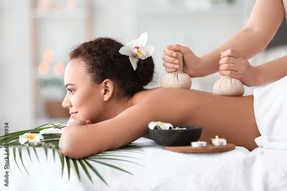 Beautiful young African-American woman getting massage in spa salon