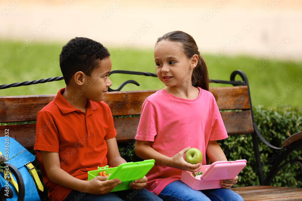 可爱的小孩在户外吃学校午餐